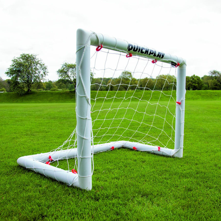 Mini-but de football Q-FOLD 90 x 75 cm sur un terrain en herbe, vu depuis un angle avant.