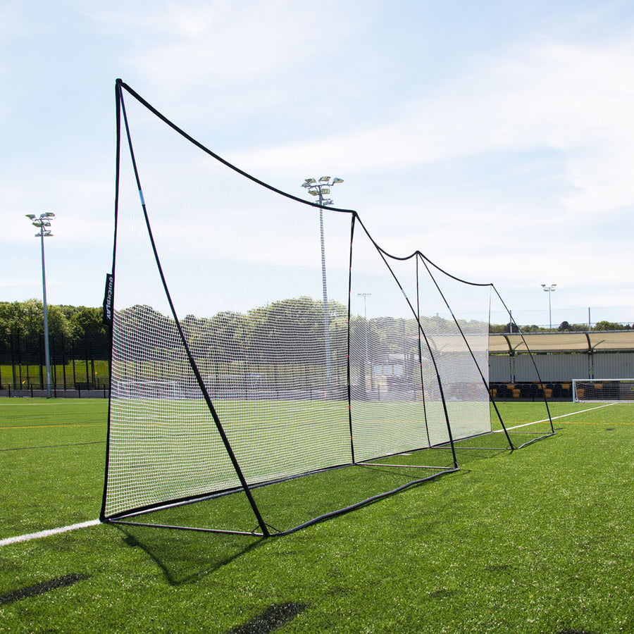 MEGA NET XL 980 x 270 cm vu depuis l'extrémité, montrant les mâts noirs incurvés et les cadres de base sur du gazon synthétique.