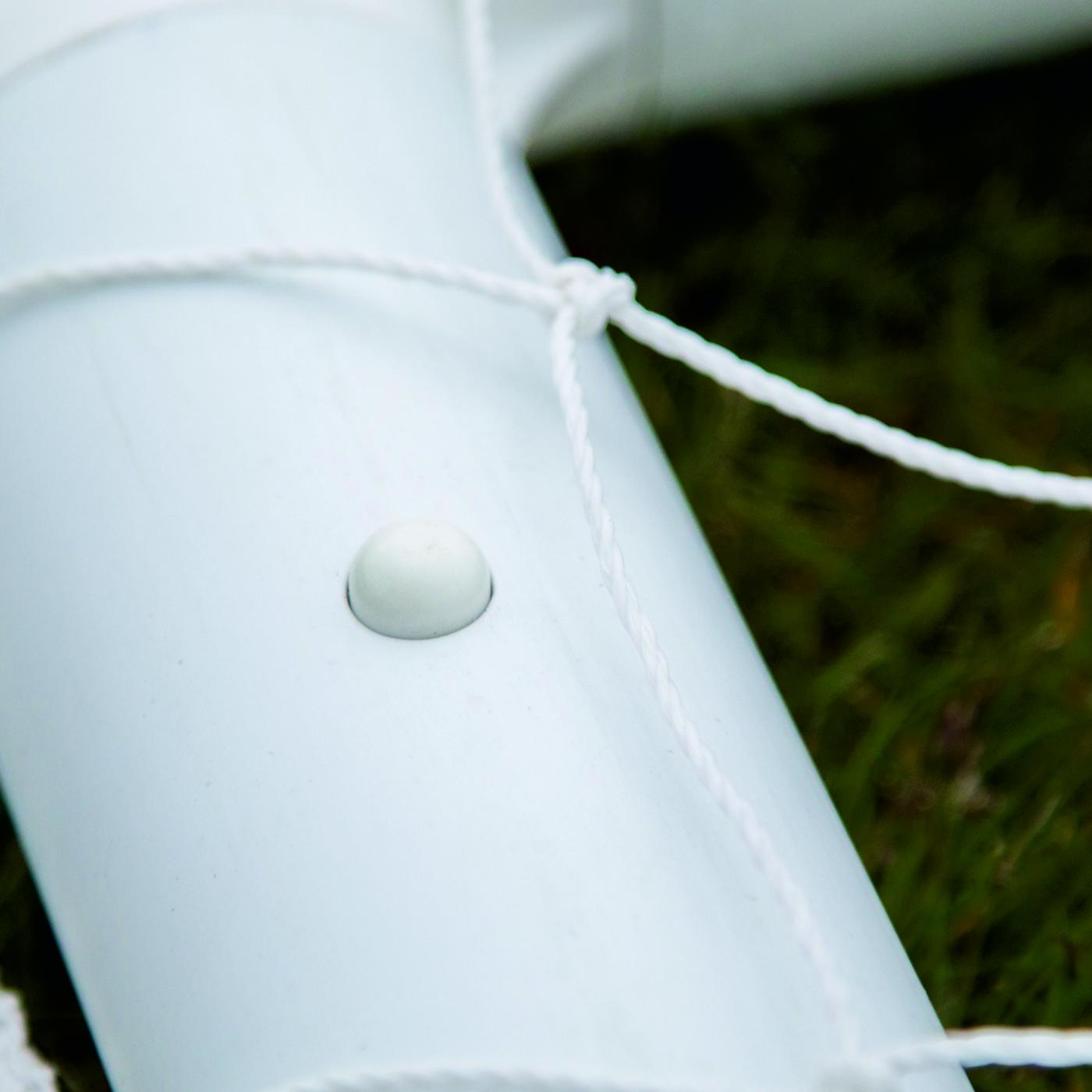Gros plan d'un bouton rond blanc sur le tube blanc du cadre du mini-but de football Q-FOLD 90 x 75 cm.