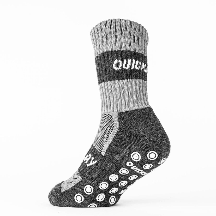 Chaussette grip QUICKPLAY seule, vue de côté : bord-côte gris clair avec bande QUICKPLAY, pied gris foncé et pastilles antidérapantes.