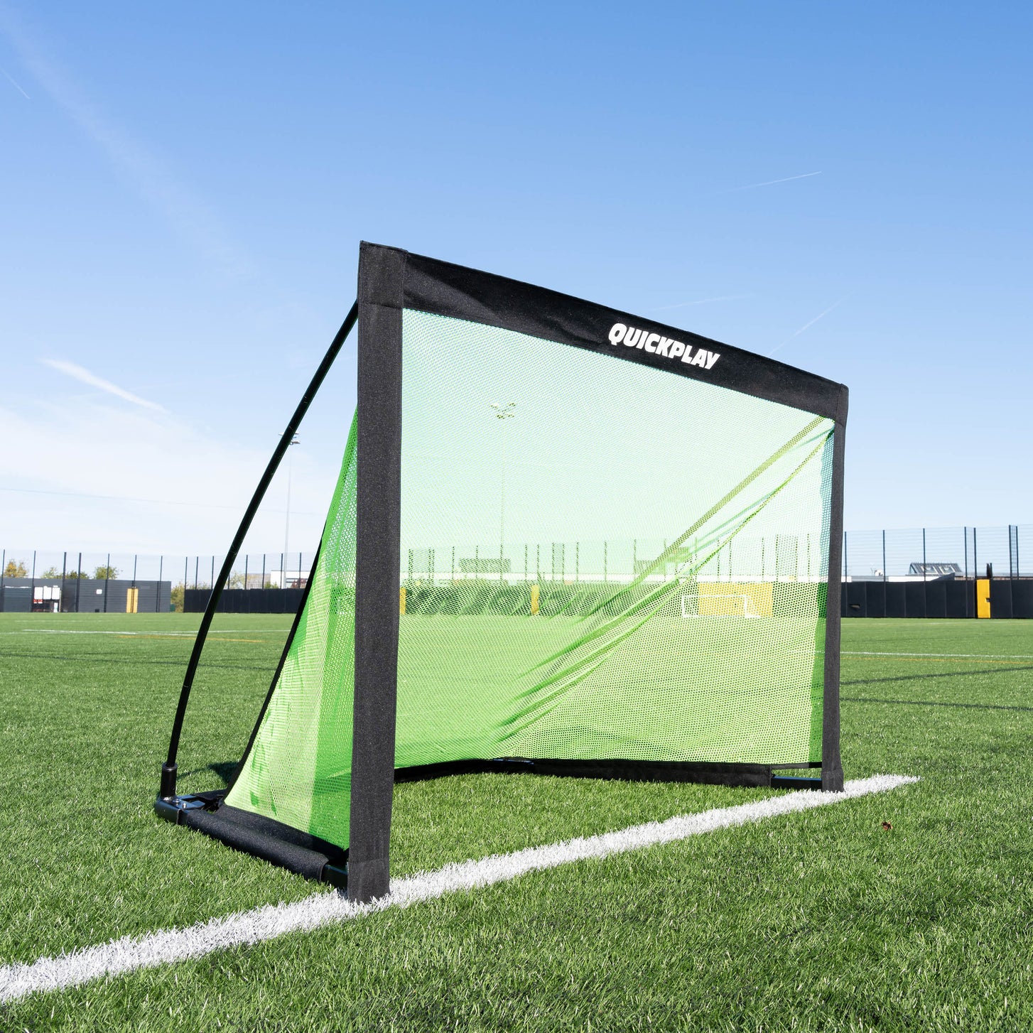 But KICKSTER PRO 120 x 75 cm sur un terrain synthétique, vue de trois quarts avant, avec QUICKPLAY sur le fourreau de la barre transversale.