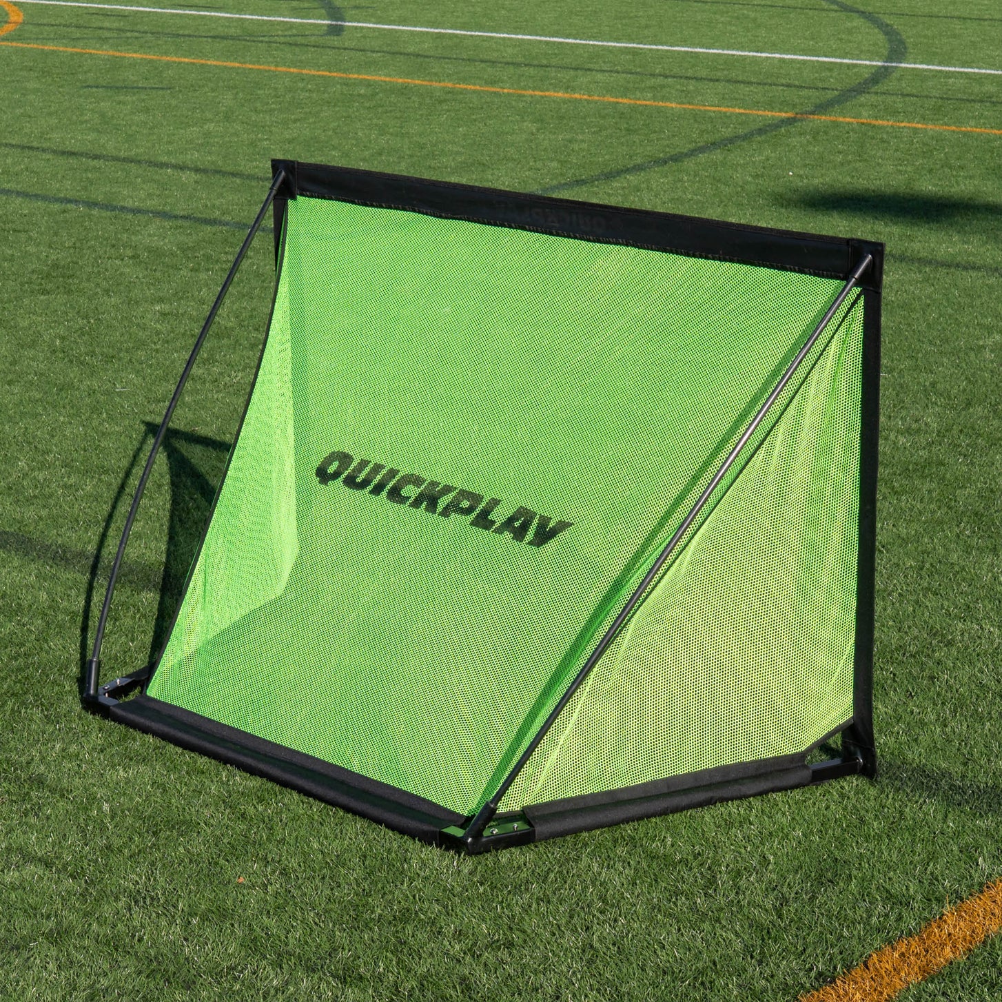 But KICKSTER PRO 120 x 75 cm sur gazon synthétique, vu de face en plongée, avec QUICKPLAY sur le filet vert.