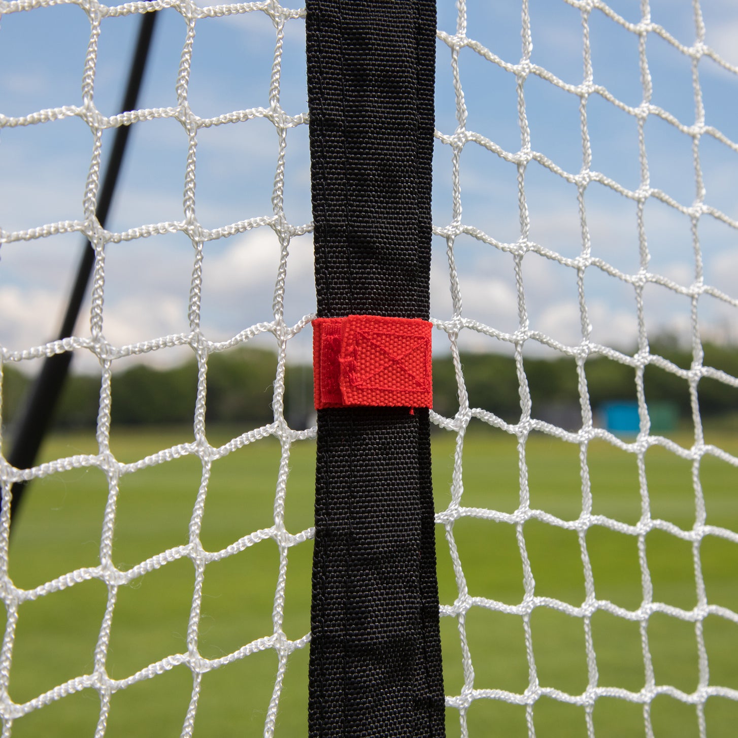 Gros plan du filet d'extension 240 x 270 cm pour MEGA NET : sangle noire avec une languette rouge sur le filet blanc.