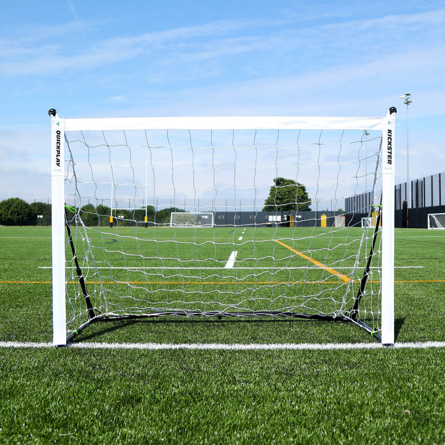 But KICKSTER Elite 150 x 100 cm vu de face, avec un filet blanc, sur la ligne d'un terrain synthétique.