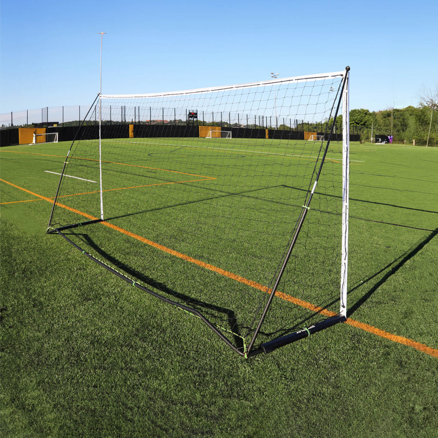 But KICKSTER Elite 500 x 200 cm vu de derrière sur un terrain synthétique, montrant le cadre arrière noir et le filet.