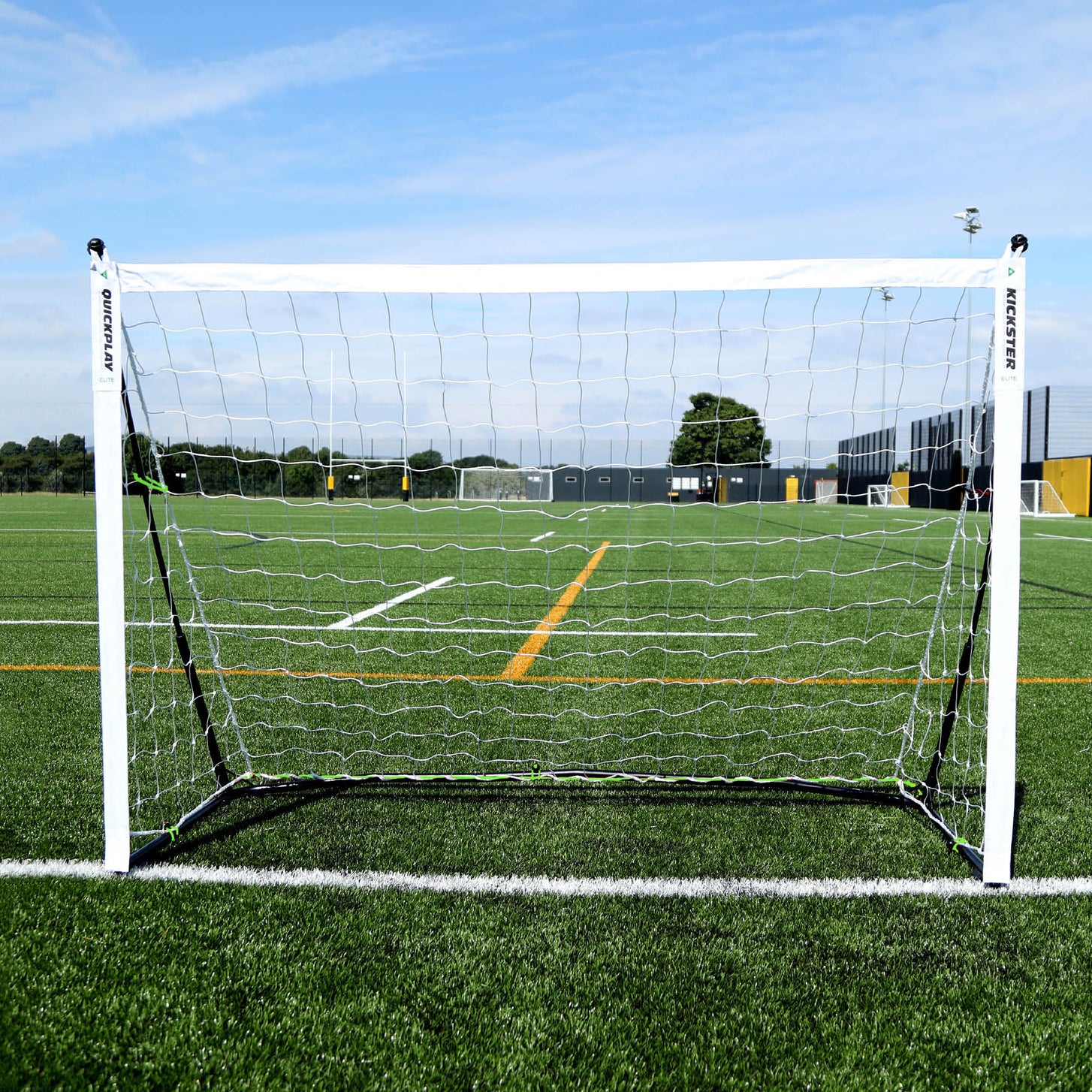 But KICKSTER Elite 180 x 120 cm vu de face sur un terrain synthétique, cadre blanc et filet blanc.