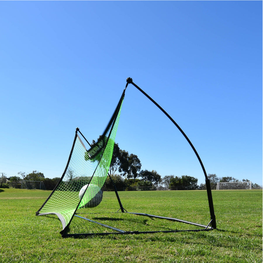 TEKKERS Net 150 x 100 cm vu de côté sur l'herbe, avec un ballon qui s'enfonce dans son filet vert.