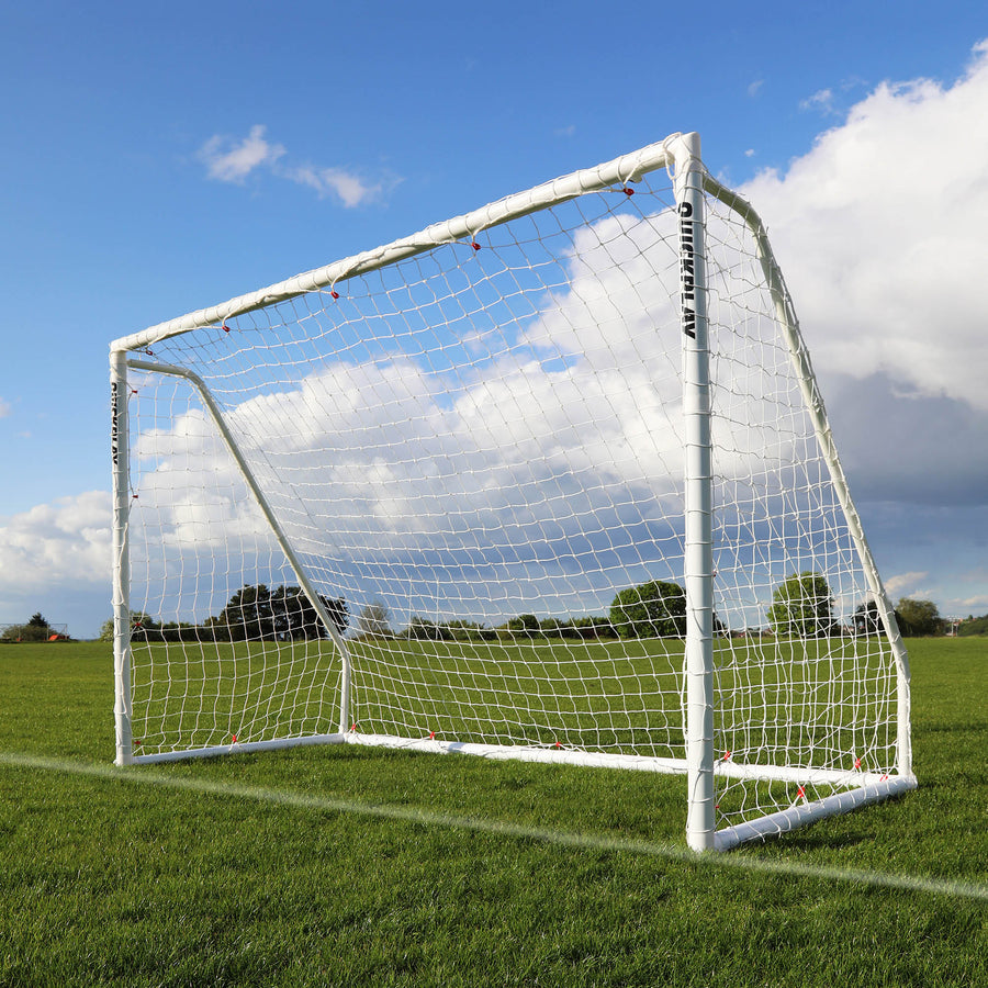 But de futsal pliable Q-FOLD Match 300 x 200 cm avec cadre et filet blancs, posé sur l'herbe sous un ciel bleu.