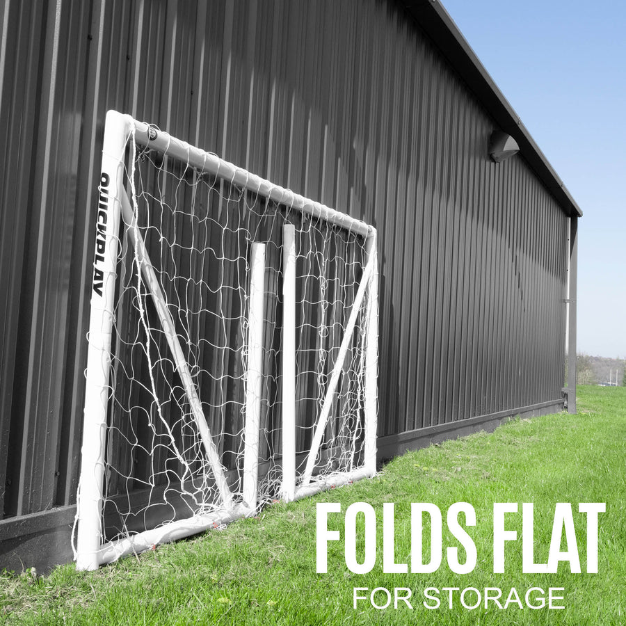 But de football Q-FOLD 240 x 150 cm plié et appuyé contre un bâtiment en métal sombre, avec le texte « folds flat for storage ».