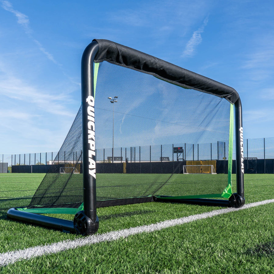 But de football RHINO 120 x 75 cm avec un cadre noir épais et un filet noir, posé sur la ligne d'un terrain synthétique.
