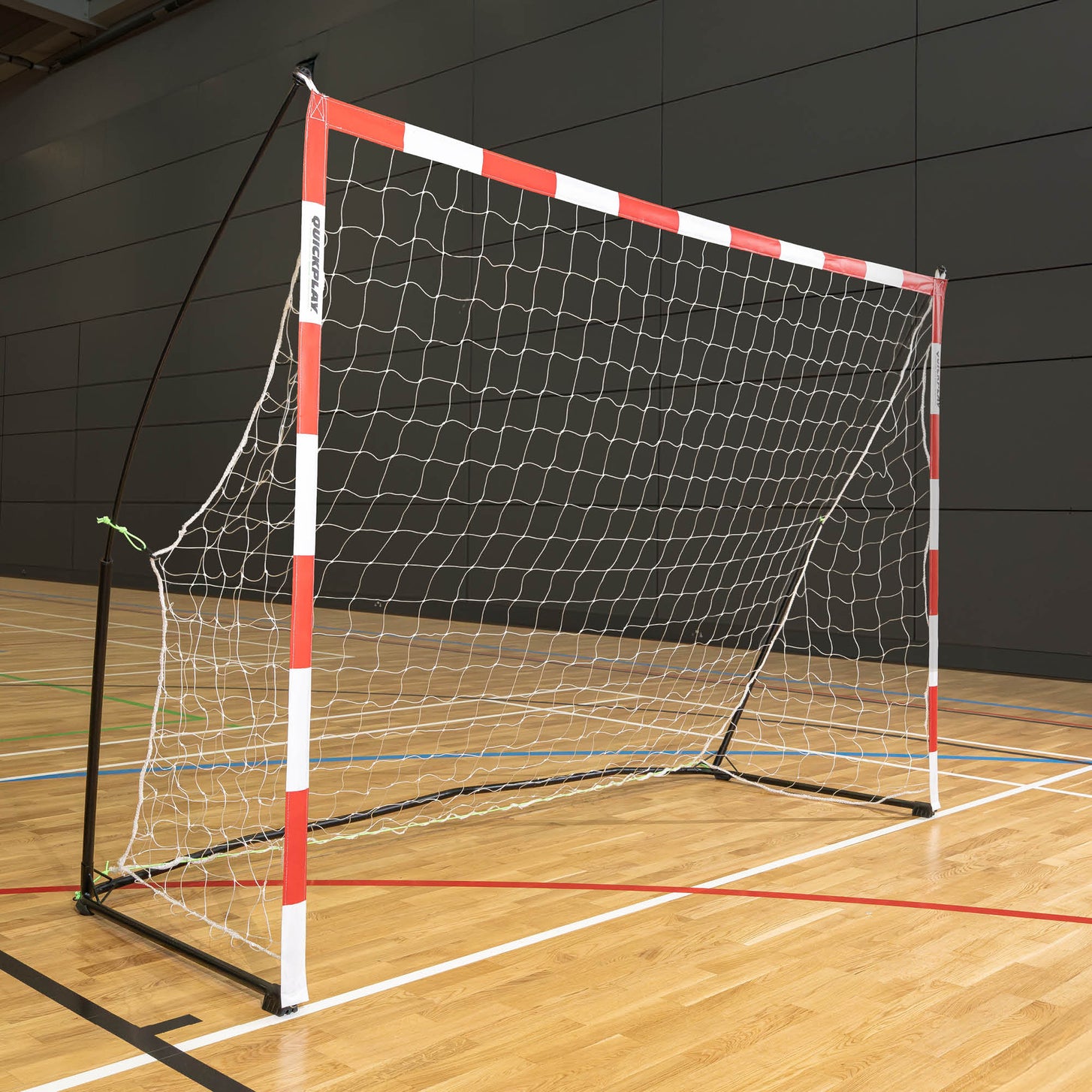 But de minihand transportable 240 x 170 cm avec poteaux rouges et blancs, filet blanc et cadre noir, installé dans une salle de sport.