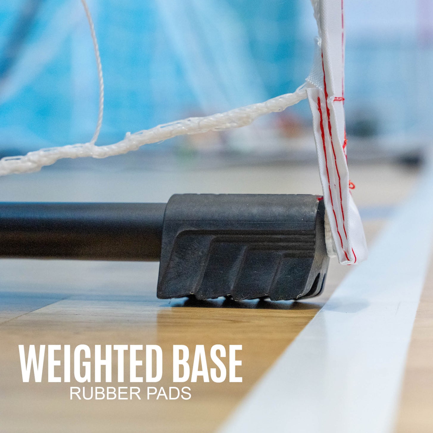 Gros plan de la base du but de minihand transportable 240 x 170 cm sur le sol d'une salle, avec le texte « weighted base, rubber pads ».